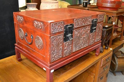 Lot 1504 - An Eastern red lacquered leather small trunk, with dragon decorated front and on short legs,...