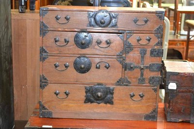 Lot 1512 - A Korean elm small chest of drawers, with side carrying handles and decorative angle...