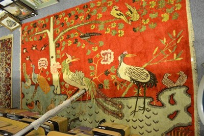 Lot 1549 - A Chinese wool rug, worked with various birds in a stylised garden landscape, 160cm by 268cm; a...