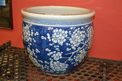 Lot 1572 - A 19th century Chinese fish bowl decorated with growing prunus blossom in under glazed blue, 40.5cm