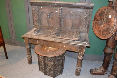 Lot 1592 - An oak side table with super structure carved back support, width 125cm and an eastern folding...