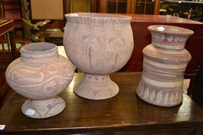 Lot 1670 - A red painted terracotta ovoid pedestal jar, age unknown, perhaps South American Indian, 32cm high