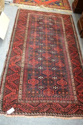 Lot 1672 - Balouch rug, Persian/Afghan frontier, the indigo lattice field with stylised flowerheads...