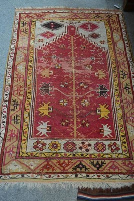 Lot 1673 - Anatolian Prayer rug, The raspberry field with stylised 'Tree of Life' beneath the Mihrab, 160cm by