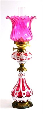 Lot 61 - A Bohemian overlay oil lamp with pink glass shade