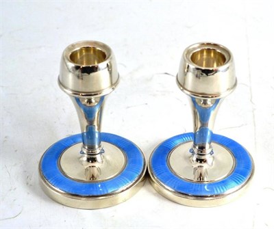 Lot 70 - A pair of silver and enamel candlesticks