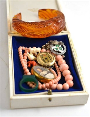 Lot 253 - A carved amber type bangle, a coral bead necklace, a locket etc