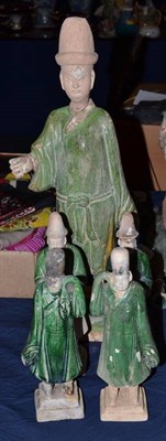 Lot 305 - A Chinese glazed terracotta attendant, Ming period, 42cm high; and four similar smaller figures (5)