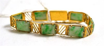 Lot 12 - A jade type bracelet, oblong panels in yellow claw mounts alternate with geometric panels,...