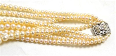 Lot 16 - A four strand cultured pearl necklace with a diamond set Art Deco style clasp, estimated...