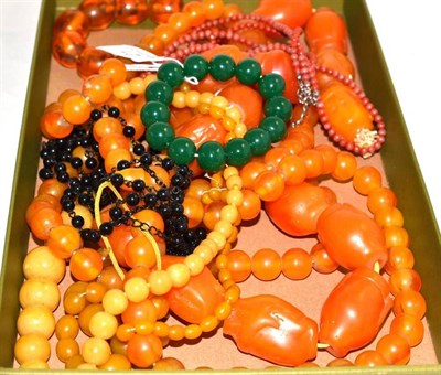 Lot 21 - An amber type bracelet, green jade type bracelet, four amber coloured necklaces, jet bead...