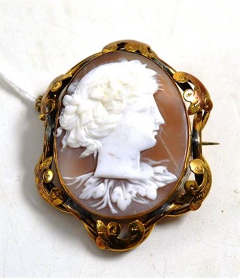 Lot 28 - A cameo brooch, carved with a Baccante, in a scrolling frame (unclear signature to the reverse...