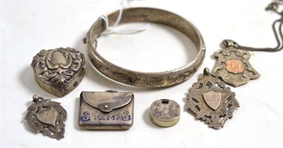 Lot 38 - A half engraved silver bangle, three silver shields, a silver stamp case and two other items (7)