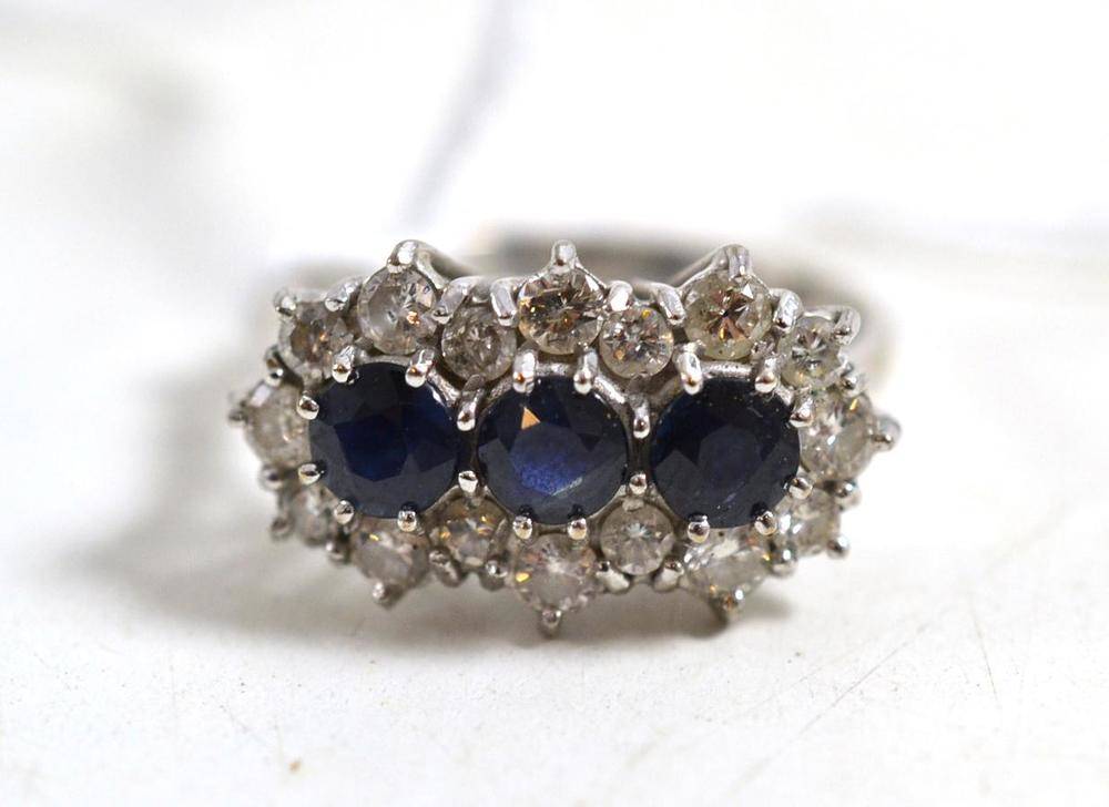 Lot 44 - A sapphire and diamond triple cluster ring, stamped '18CT', round mixed cut sapphires within a...