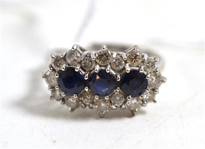 Lot 44 - A sapphire and diamond triple cluster ring, stamped '18CT', round mixed cut sapphires within a...