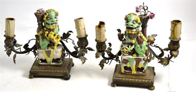 Lot 103 - Pair of French gilt metal low candelabra set with porcelain Buddhistic lions, 22cm high