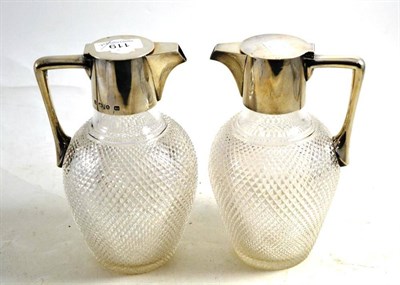 Lot 119 - A near pair of silver claret jugs