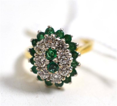 Lot 212 - An 18ct gold emerald and diamond oval shaped cluster ring, total estimated diamond weight 0.70...