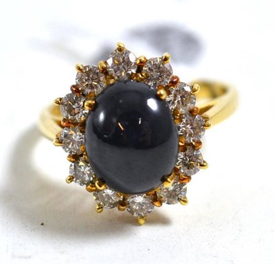 Lot 248 - An 18ct gold star sapphire and diamond cluster ring, an oval cabochon star sapphire within a border