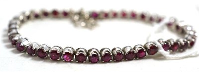 Lot 264 - A ruby set line bracelet, in white claw settings, length 18.5cm