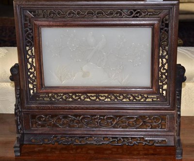 Lot 338 - A Chinese table screen, 20th century, foliate fretted stand enclosing relief carved white stone...