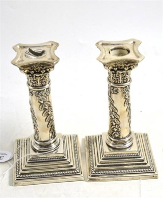 Lot 351 - A pair of Edward VII silver Corinthian column candlesticks, Birmingham 1902