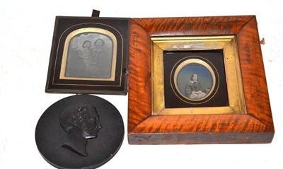 Lot 366 - An ambrotype in a maple frame, a daguerreotype of two young girls and a Bois Durci roundel of...