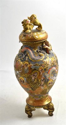 Lot 401 - A Japanese Satsuma earthenware tripod vase and cover, circa 1900, with shi-shi dog finial, the neck