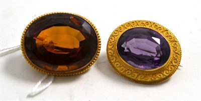 Lot 594 - A citrine brooch, stamped '15ct', measures 3.2cm by 2.6cm and an amethyst brooch with a scroll...