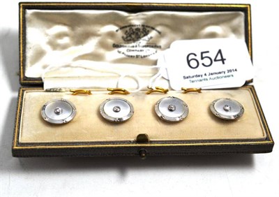 Lot 654 - A cased set of mother of pearl and diamond set dress buttons stamped to the back '18ct'