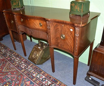 Lot 683 - An Edwardian mahogany serpentine shaped sideboard