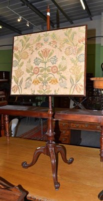 Lot 729 - A late Georgian mahogany pole screen, with rectangular woolwork floral panel, on triple...