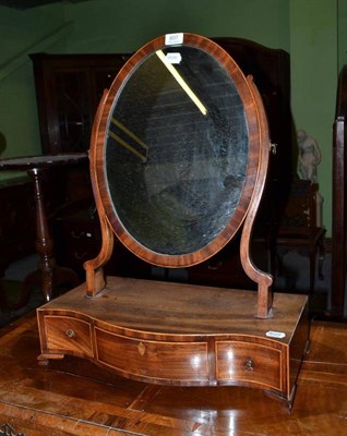 Lot 807 - A George III mahogany serpentine toilet mirror with oval swing plate, fitted with three drawers, on