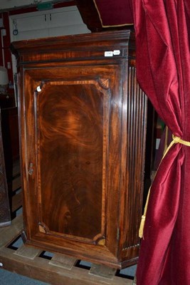 Lot 1246 - A George III mahogany corner cupboard with fluted stiles