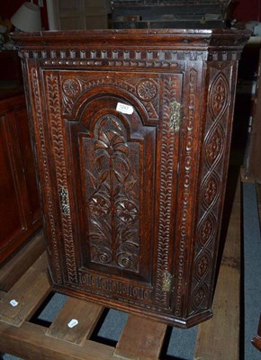 Lot 1247 - An 18th century oak hanging corner cupboard, later carved