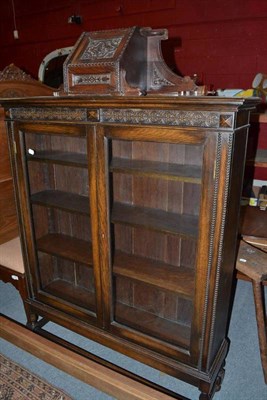 Lot 1250 - A glazed oak two door bookcase and a carved oak small corner cupboard