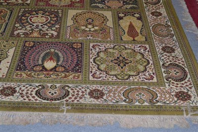 Lot 1344 - Machine made carpet of oriental design, the compartmentalised field of polychrome flowers and...