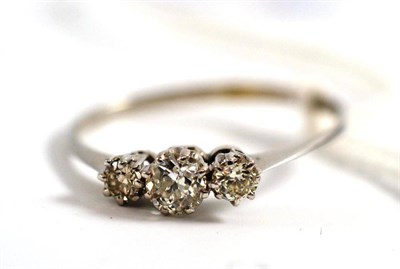 Lot 68 - A diamond three stone ring, the graduated old cut diamonds in a white gold claw setting, on a...