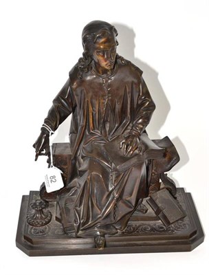 Lot 82 - A late 19th century bronze of a scholar, sitting reading with maps and books around his feet,...