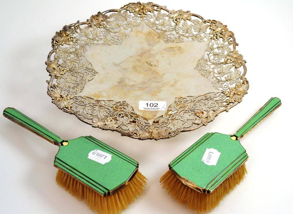 Lot 102 - A George V cake stand, Sheffield 1931, with fruiting vine borders, 31cm diameter; and a pair of Art