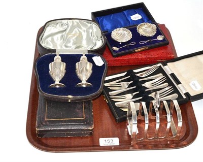 Lot 153 - A silver toast rack; a cased pair of silver pepperettes; a cased pair of silver shell salts and...