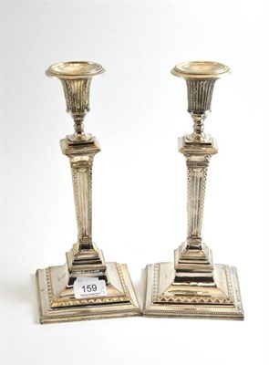 Lot 159 - A pair of plated on copper candlesticks, engraved with a crest, 28cm high