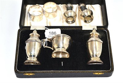 Lot 186 - A silver three piece condiment set, cased, a pair of baluster salts and a pair of napkin rings