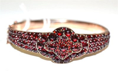 Lot 201 - A garnet type cluster bangle, rose cut stones claw set throughout the hinged bangle