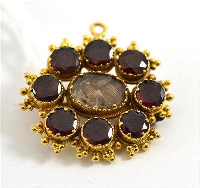 Lot 212 - A garnet mourning brooch, the round garnets surround a locket enclosing plaited hair, within an...