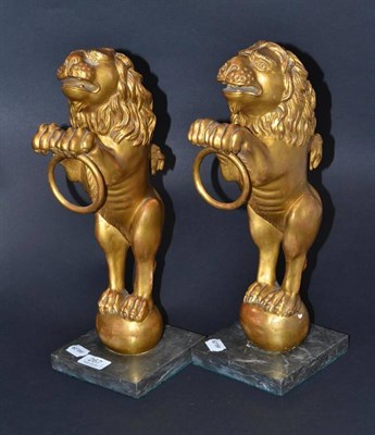 Lot 267 - A pair of giltwood heraldic lions rampant, on faux marble bases, 29cm high