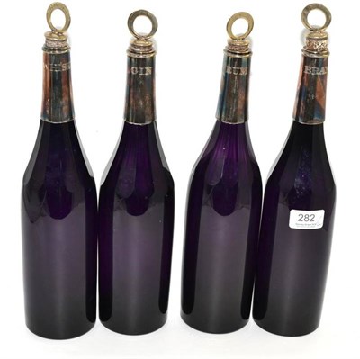 Lot 282 - A set of four early 19th century amethyst glass spirit decanters with plated mounts and...