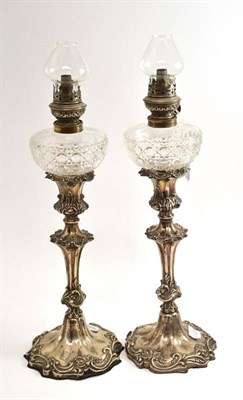 Lot 320 - A pair of Victorian silver candlestick oil lamps, Sheffield 1845, 48cm high including chimneys