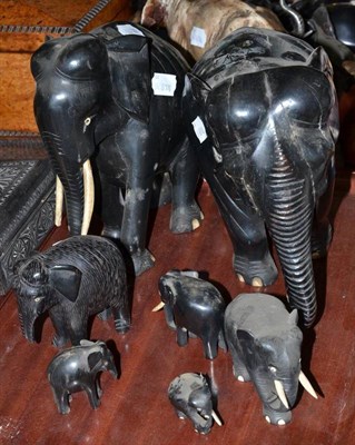 Lot 332 - An ebony model of an elephant, 24cm high; a similar model of an elephant, 24cm high; and five...