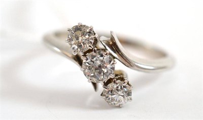 Lot 381 - A diamond three stone twist ring, the old cut diamonds in white claw settings, between tapered...